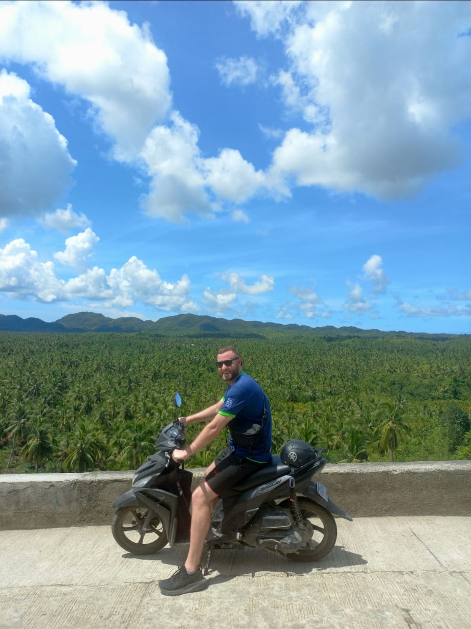 Brandon riding a motorbike in the Philippines