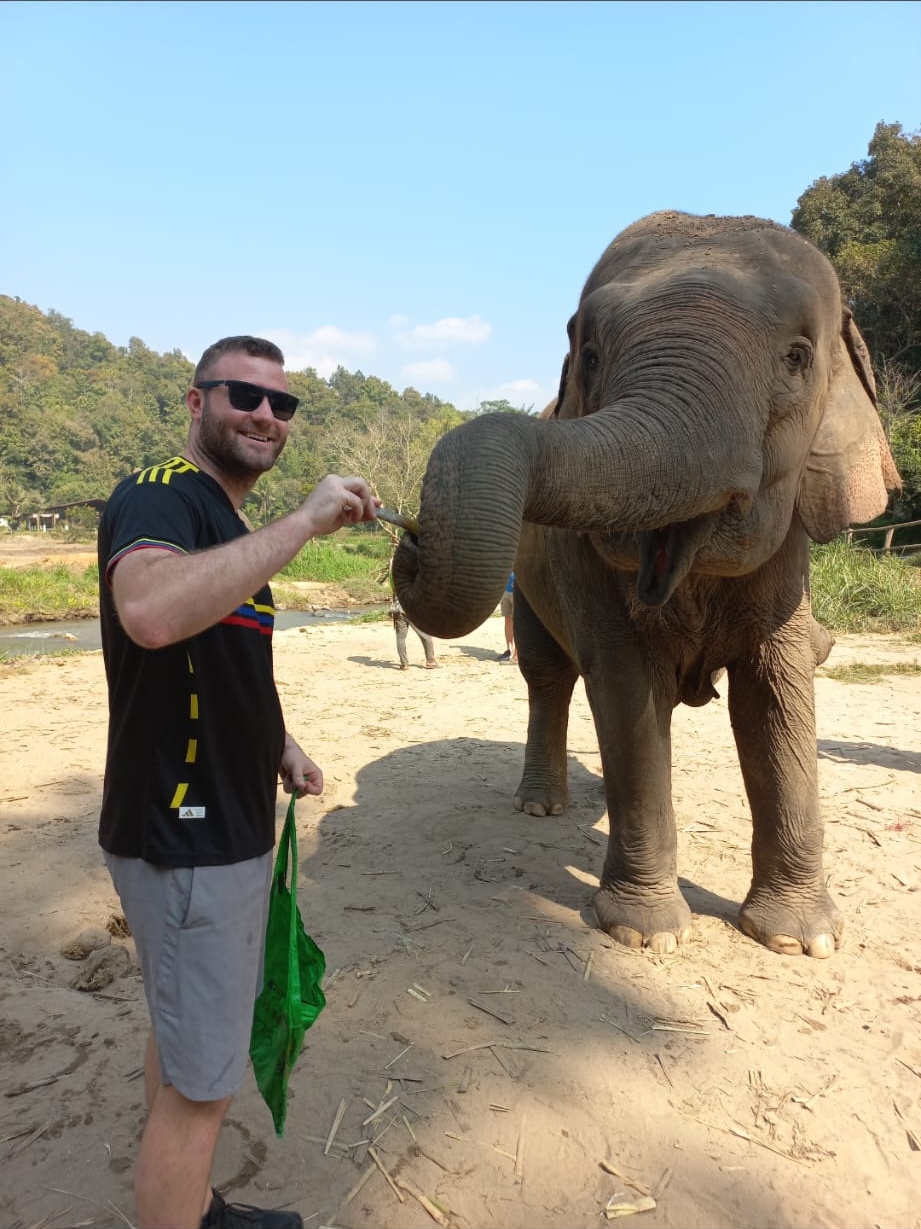 Brandon feeding an elephant in Thailand